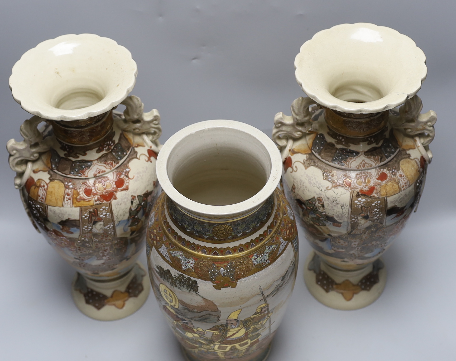 A pair of late 19th century Japanese Satsuma vases and a similar example, the largest each 42cm high (3)